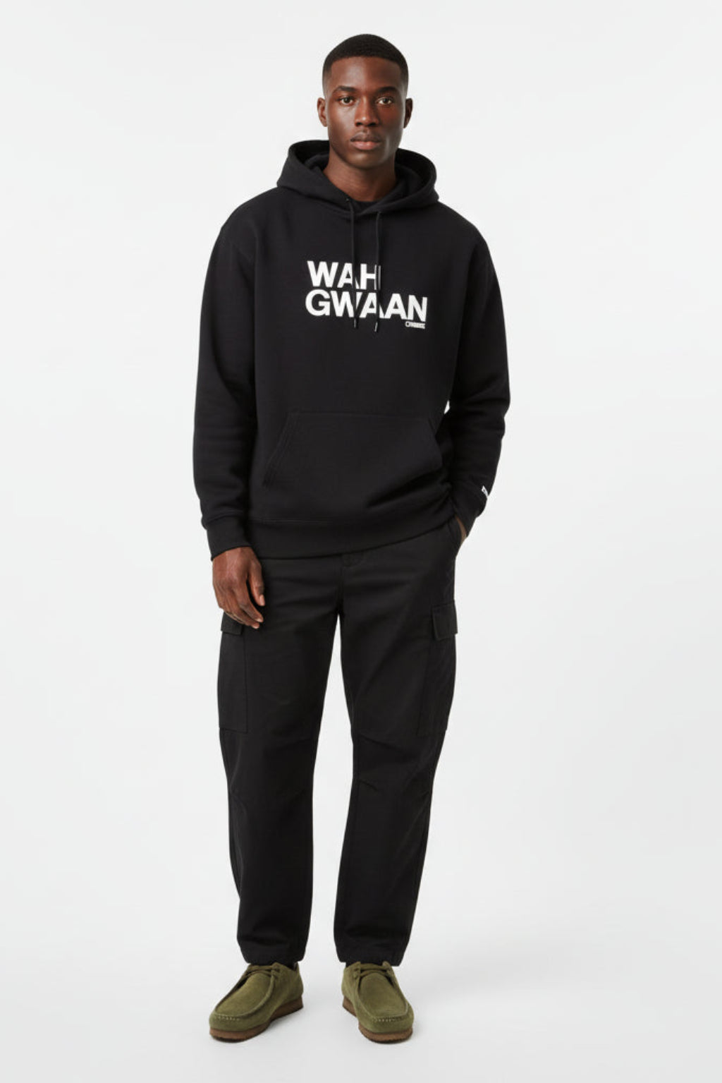 Man wearing a black hoodie with 'WAH GWAAN' text on a white background