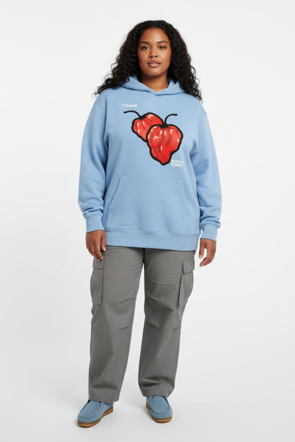 Woman wearing a Scotch Bonnet graphic hoodie on a white background